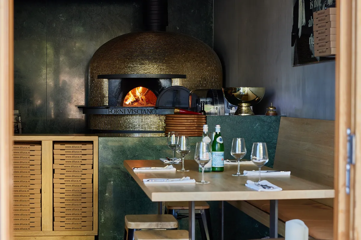 The oven at the back of the dining room, a table laid in front