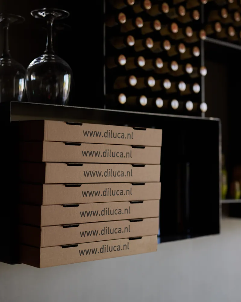 Di Luca pizza boxes under the wine rack