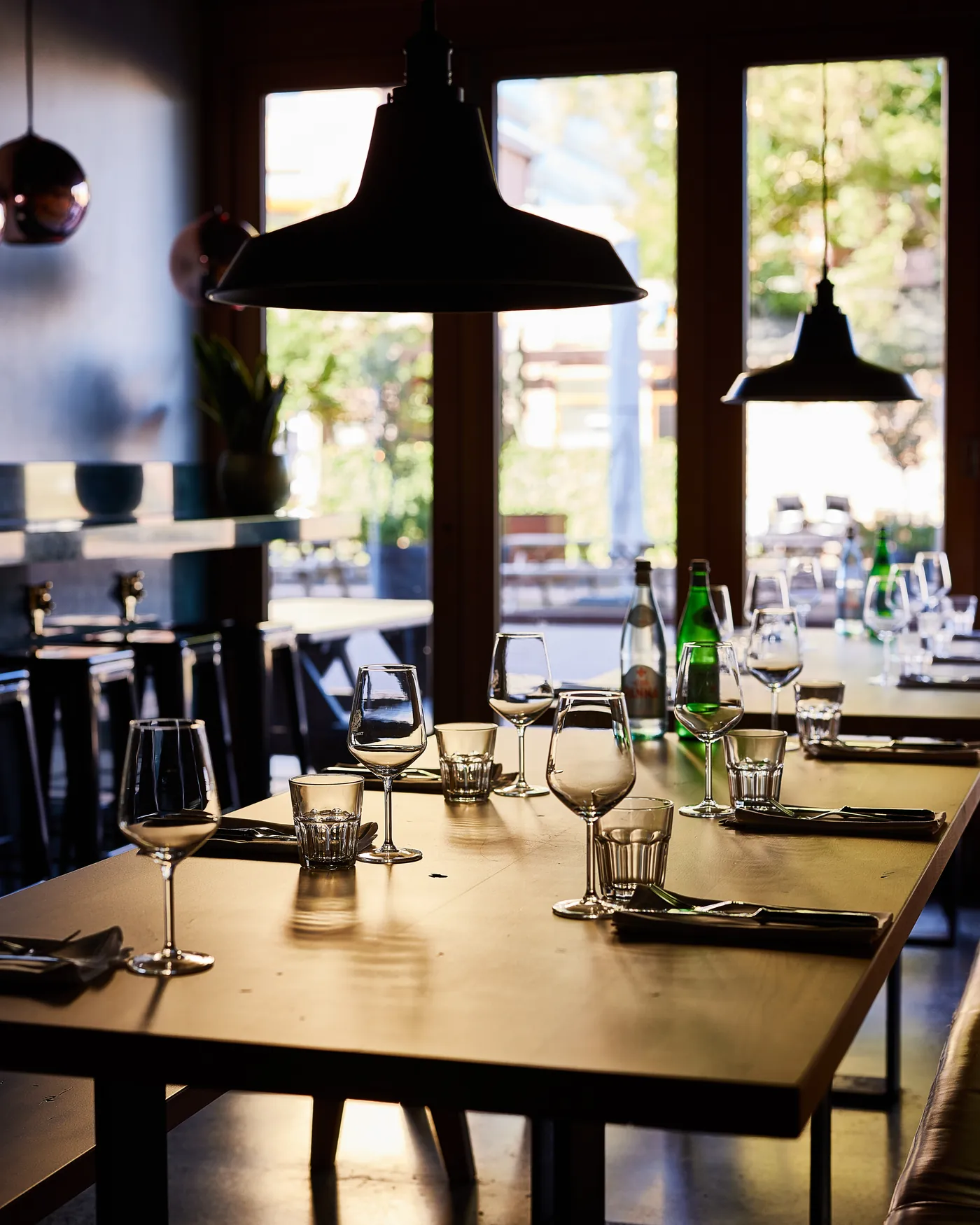 A long table laid in the evening sun, more tables beyond it