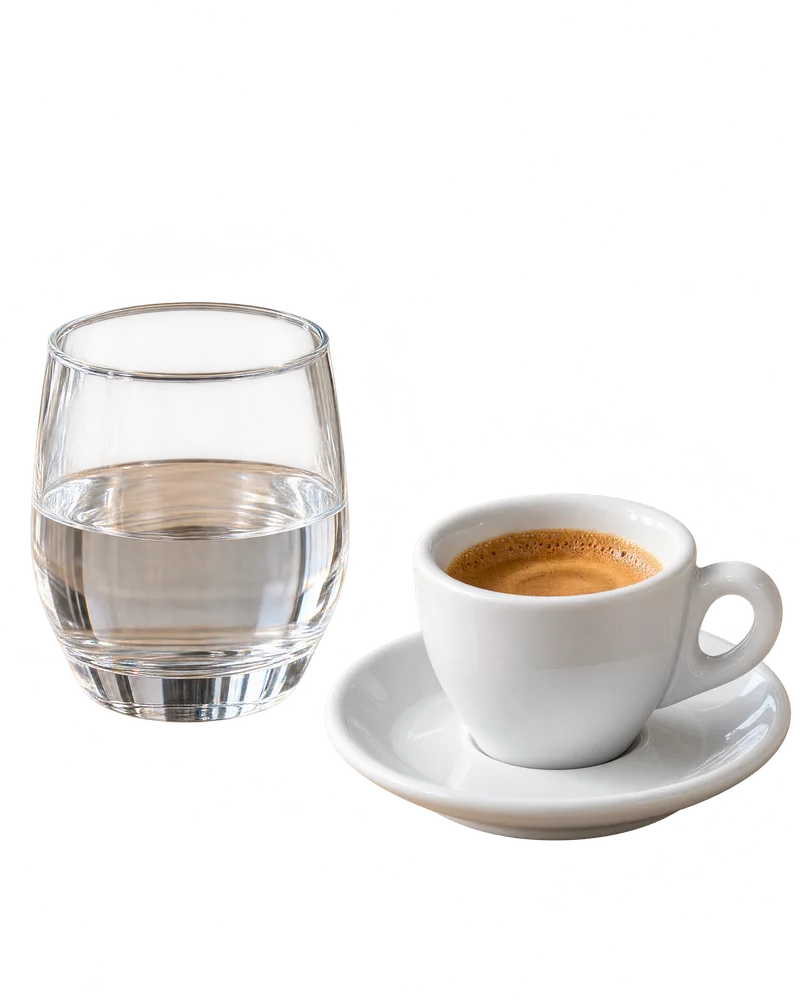An espresso beside a glass of water