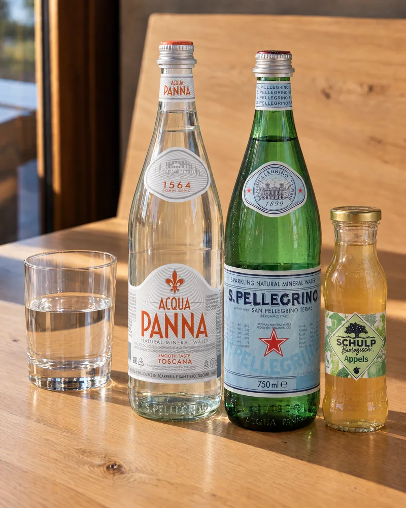 Bottles of Acqua Panna, San Pellegrino and Schulp apple juice