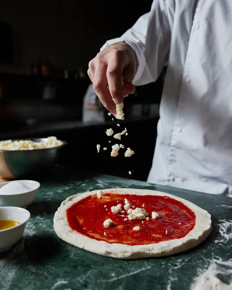 Mozzarella scattered over the sauce