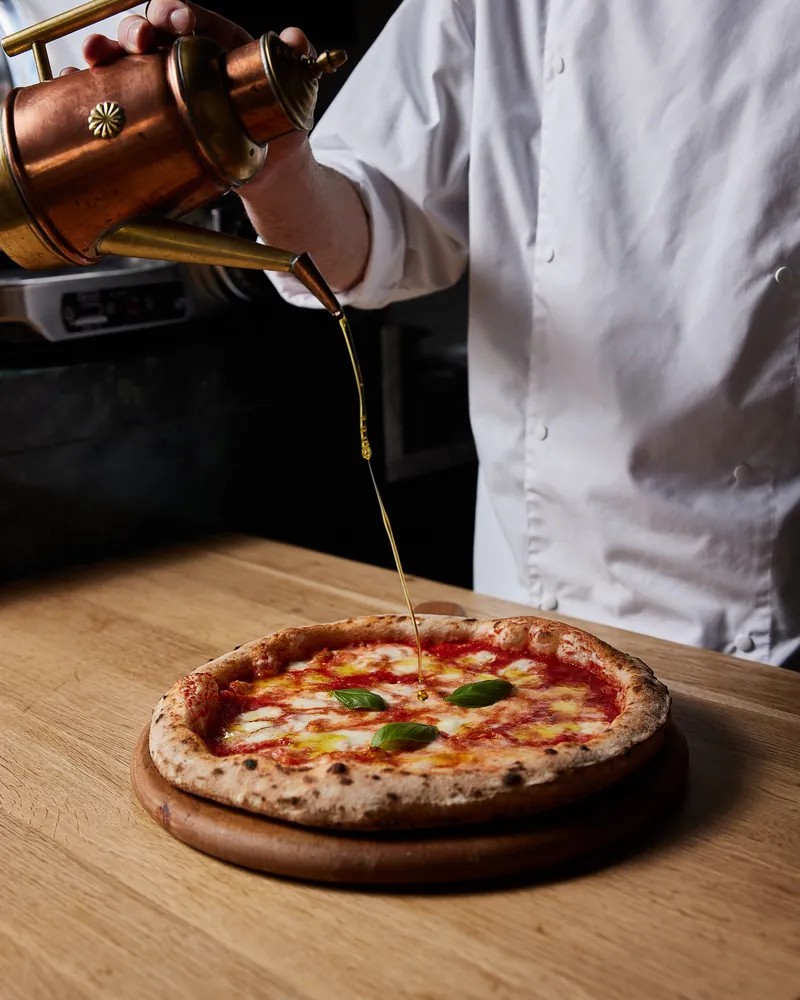 Olive oil poured over a baked pizza