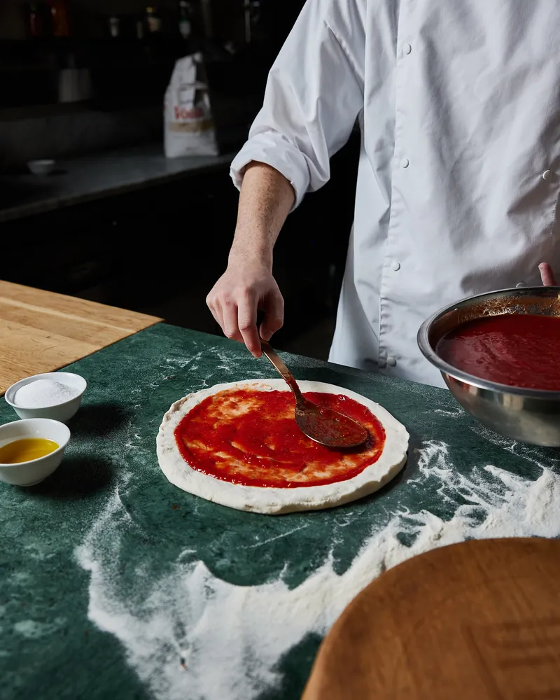Tomato sauce spread over the dough