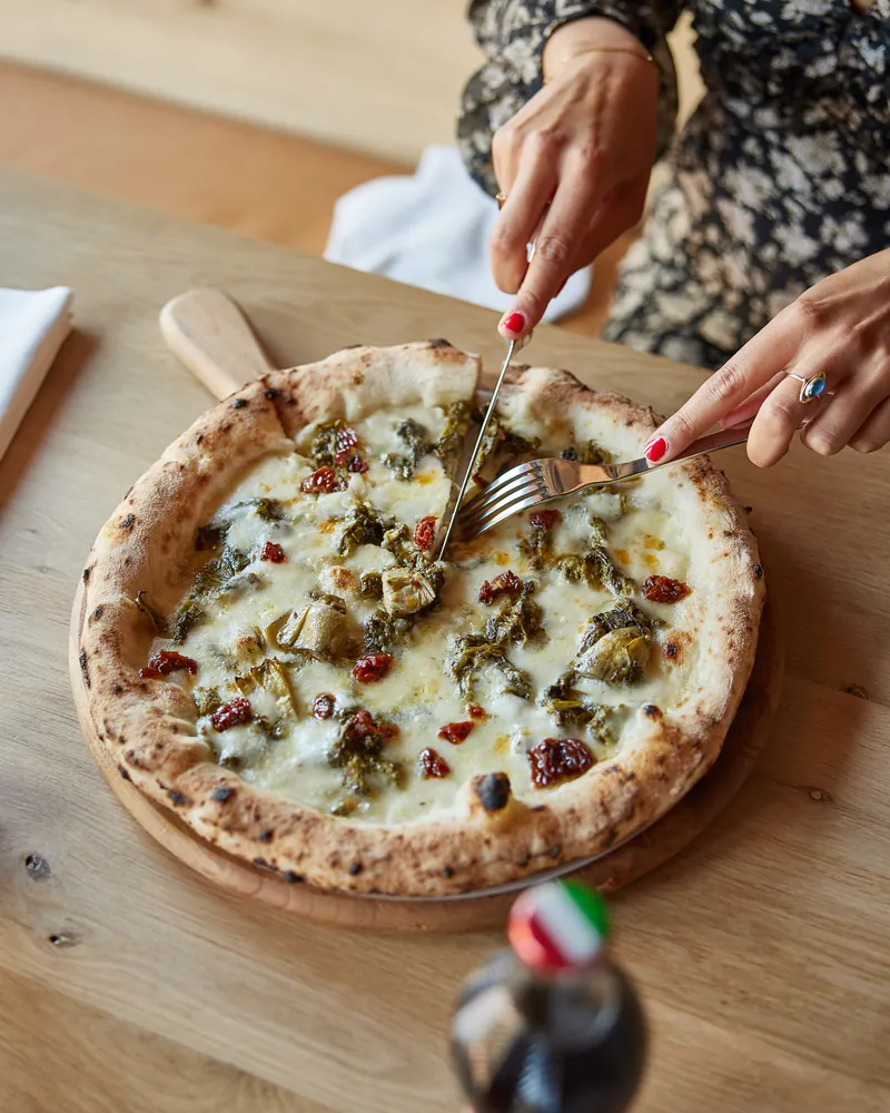 A white pizza being shared at the table