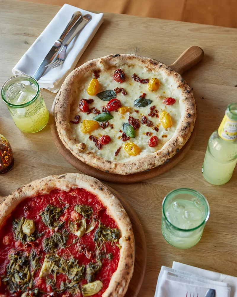 Pizzas and lemonade spread across the table
