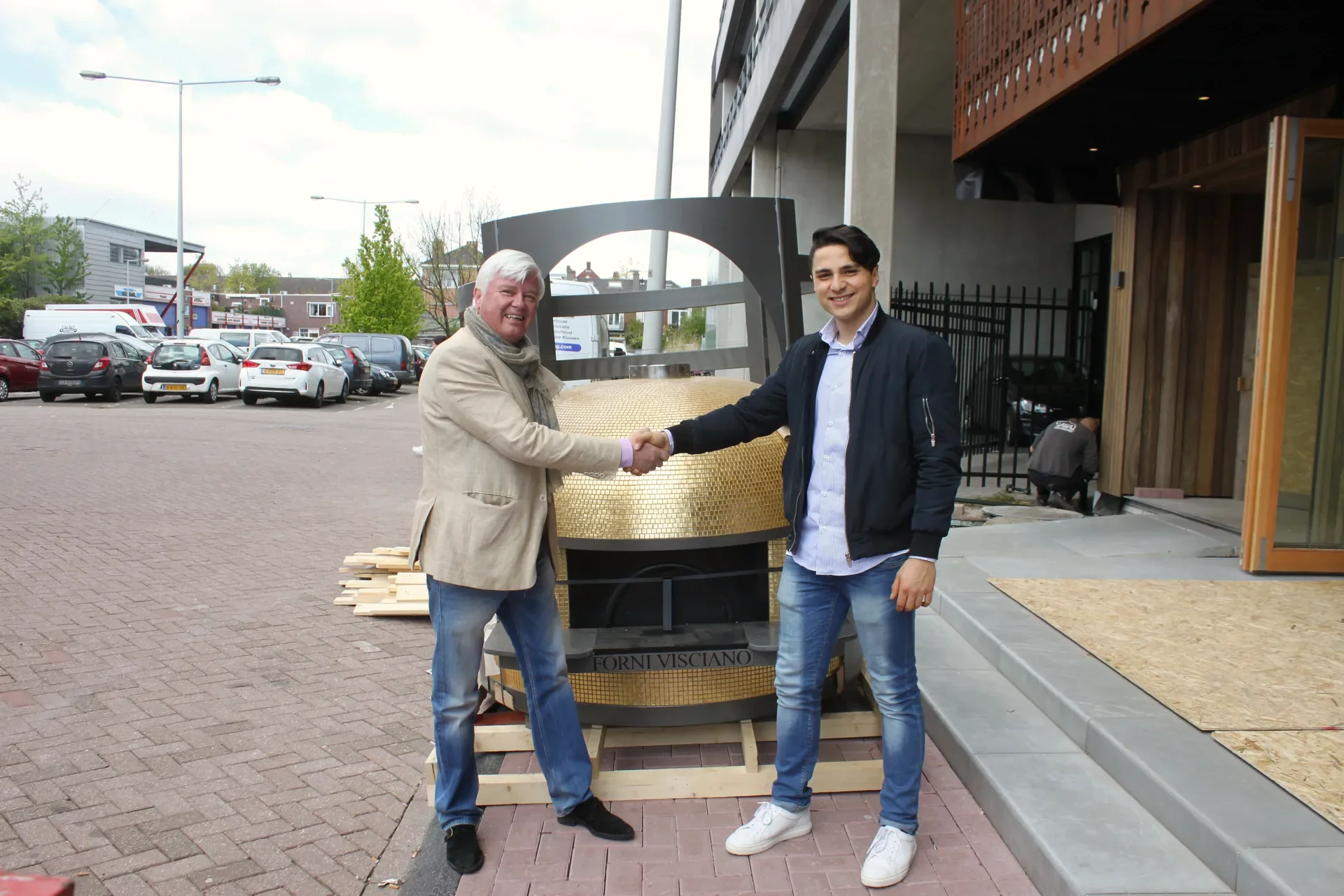 Luca shaking hands in front of the delivered oven